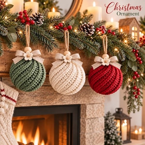 Könnte beinhalten: Drei kugelförmige Weihnachtsschmuck-Anhänger mit einem strukturierten Spiralstrickmuster in Grün, Creme und Rot. Jeder Anhänger ist mit einer beigen Stoffschleife, einer kleinen Holzblume und einer Schlaufe aus Juteschnur versehen.