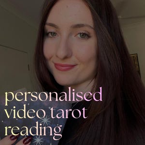 Pode incluir: Uma pessoa com cabelos longos castanhos escuros segura um baralho de cartas de tarô com um design celestial azul escuro com estrelas e constelações brancas. O texto "personalised video tarot reading" está sobreposto em rosa claro.