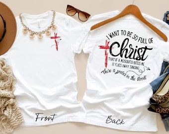 May include: White t-shirt with a red cross and the text "I want to be so full of Christ that if a mosquito bites me it flies away singing There is greater in the blood." on the back.