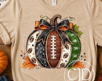 Puede incluir: Una camiseta de color beige jaspeado con un gráfico de una calabaza diseñada como un balón de fútbol americano, con cordones, un lazo negro y una sección verde que representa un campo con líneas. Manga corta y cuello redondo.