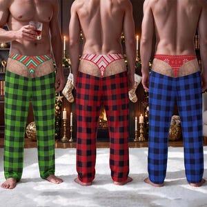 Può includere: Tre paia di pantaloni da casa con motivo a quadri in verde, rosso e blu. Ogni paio include una grafica stampata di un girovita a perizoma con motivi festivi, tra cui strisce a chevron e disegni di fiocchi di neve.