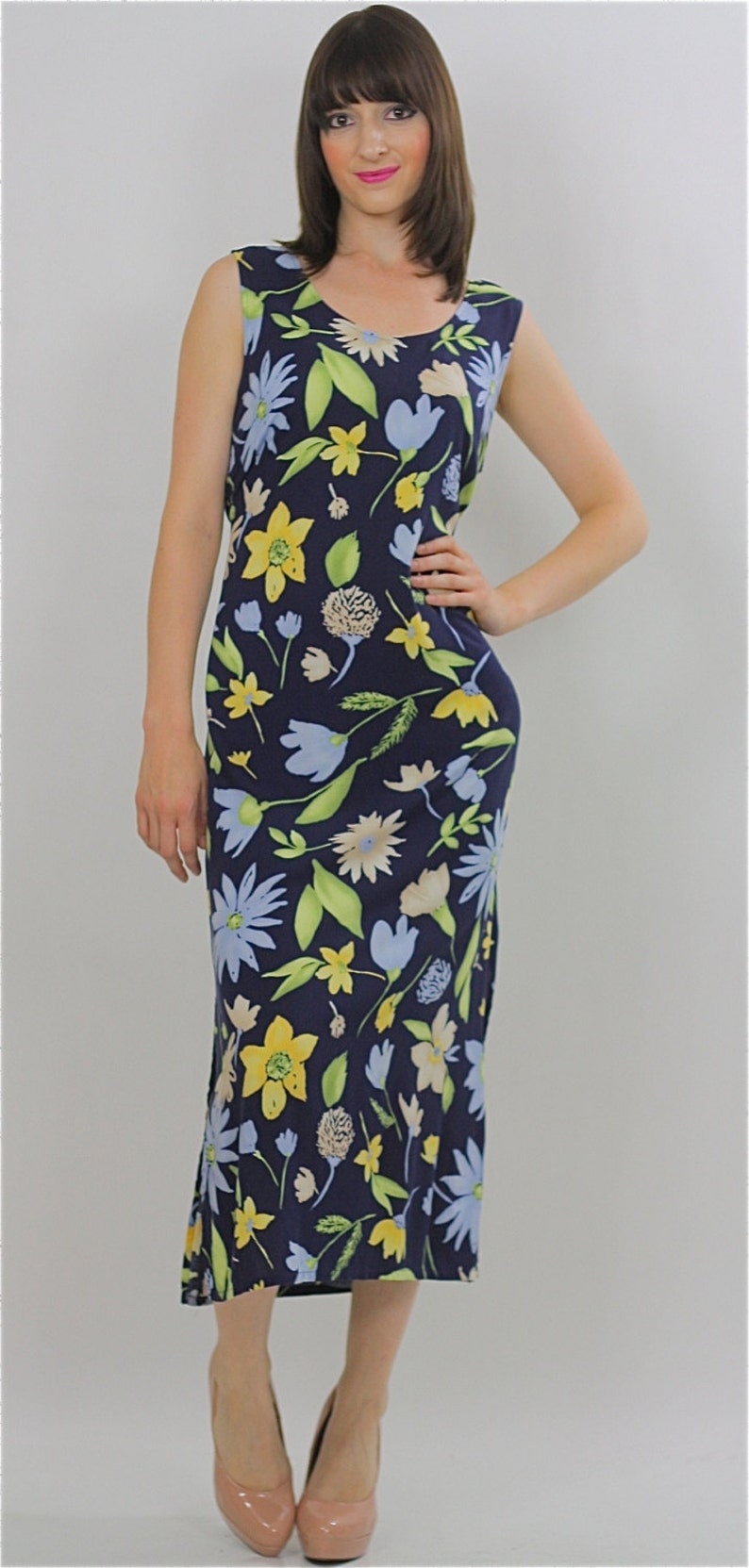 May include: A sleeveless midi dress with a floral print in shades of blue, yellow, and green on a navy background.