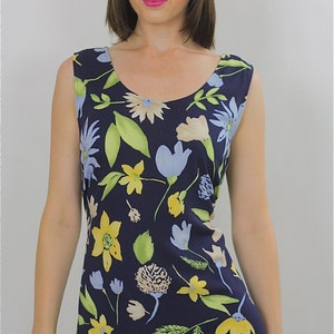 Pode incluir: Um vestido azul marinho sem mangas com estampa floral com flores amarelas, azuis e verdes. O vestido tem um decote redondo e uma silhueta ajustada.