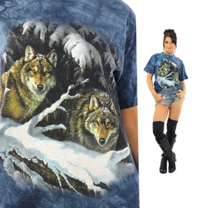 May include: A blue tie-dye t-shirt with a graphic print of two wolves in a snowy forest.