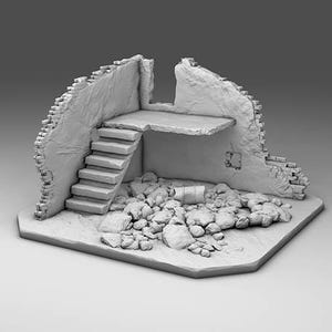 Op de afbeelding: Een grijs miniatuur diorama van een verwoeste gebouwhoek met een stenen trap die naar een verhoogd platform leidt. De grond is bedekt met verspreid puin en brokstukken, met getextureerde bakstenen muren die tekenen van schade vertonen.