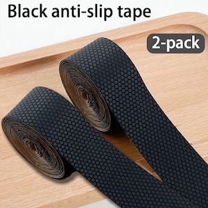 Peut inclure: Deux rouleaux de ruban adhésif antidérapant noir présentant un motif hexagonal texturé sur la surface. Le produit est étiqueté comme un pack de 2. Le ruban est enroulé en cercles, montrant une couleur sombre et un motif de grip géométrique.