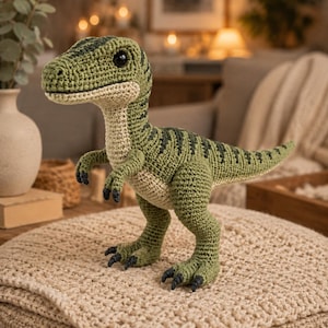 Peut inclure: Un jouet dinosaure au crochet avec un corps vert, des rayures vert foncé le long du dos et de la queue, un ventre crème et des yeux en plastique noir. La figurine se tient sur deux pattes avec de petits bras et des griffes gris foncé.