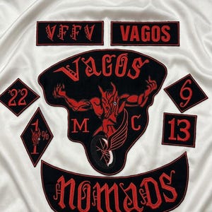 May include: A collection of black and red embroidered patches featuring the text VFFV, VAGOS, MC, and NOMADS. The central patch displays a red devil figure riding a motorcycle. Additional diamond and square patches include the numbers 22, 6, 13, and 1%.