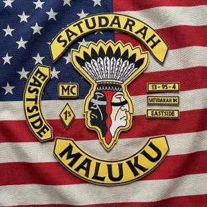 Può includere: Un set di toppe ricamate con un emblema centrale raffigurante una figura dal volto diviso con copricapo, circondato da striscioni gialli e neri con le scritte SATUDARAH, EASTSIDE e MALUKU, e toppe più piccole con le diciture MC, 1%, 13-95-4.