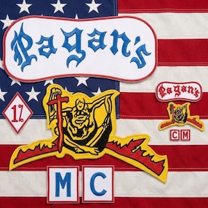 May include: A collection of embroidered patches featuring the text Pagan's in blue on a white background, a yellow and black figure holding a red sword, a diamond-shaped 1% patch, and two square patches with the blue letters M and C.