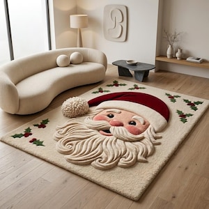 May include: A rectangular area rug featuring a large, three-dimensional tufted Santa Claus face in the center. The rug is cream-colored with a deep red hat, a white beard, and small green holly leaf and red berry accents scattered across the surface.