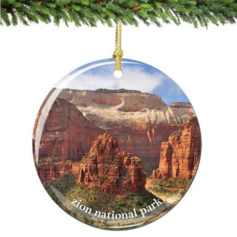 Zion National Park Christmas Ornament Porcelain Double Sided, showing a phot of zion canyon and the cliffs and formations in Zion Canyon with the red stone, it is on a circle disk