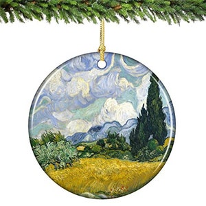 May include: A round ceramic ornament featuring a painting of a landscape with a blue sky, white clouds, green trees, and a yellow field. The painting is reminiscent of the style of Vincent van Gogh.