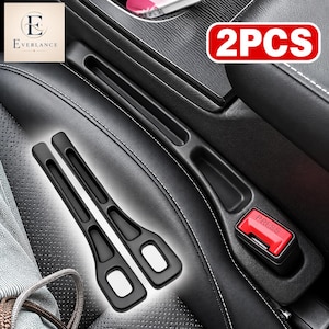 Könnte beinhalten: Zwei schwarze Lückenfüller für Autositze, die zwischen Mittelkonsole und Sitz passen. Diese mattschwarzen Organizer haben eine lange, schmale Form mit einer rechteckigen Aussparung am unteren Ende zur Aufbewahrung kleiner Gegenstände im Auto.