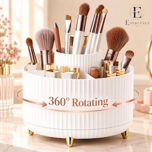 Puede incluir: Un organizador de maquillaje blanco, cilíndrico y giratorio de 360 grados con detalles acanalados verticales y pies dorados. Cuenta con múltiples compartimentos llenos de varios pinceles de maquillaje y tubos cosméticos. El logo de Everlance es visible arriba a la derecha.