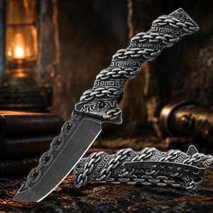 May include: A folding knife with a dark gray blade and a silver-toned handle featuring a raised, textured chain-link pattern. The handle includes a black pocket clip on the side, and the blade is partially decorated with a matching chain-link design.