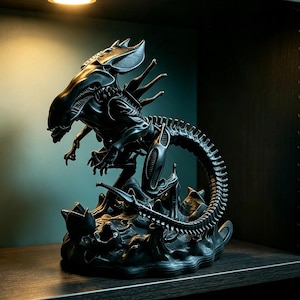 Puede incluir: Una figura negra de la Reina Xenomorfa con cabeza alargada, extremidades afiladas y una larga cola segmentada. La criatura está en una postura dinámica sobre una base texturizada que incluye varias estructuras pequeñas en forma de huevo abierto.