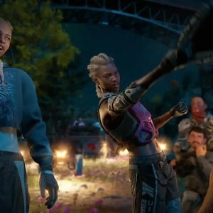May include: Two individuals in athletic gear stand in an outdoor setting. One wears a blue cropped hoodie with a graphic eye design and dark trousers. The other wears a pink chest protector, dark athletic trousers, and reaches out with a dark glove.