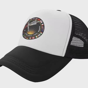 May include: A black and white trucker cap featuring a circular patch on the front panel. The patch displays a spacecraft illustration, a sunburst, and the text Project Hail Mary, surrounded by a border of various international flag icons.