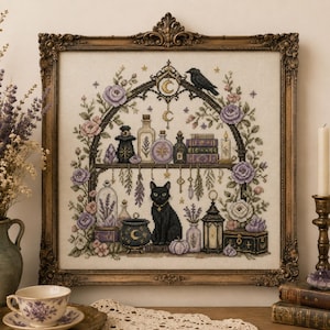 Peut inclure: Une broderie au point de croix carrée encadrée dans un cadre orné de couleur bronze. Le motif représente un chat noir assis devant un chaudron, entouré d'étagères de flacons, de livres, d'une lanterne et d'un corbeau, le tout encadré de fleurs.