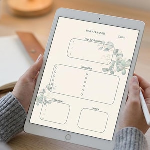 Könnte beinhalten: Ein digitales Tablet mit einer Tagesplaner-Vorlage auf cremefarbenem Hintergrund und grünen Eukalyptusblatt-Illustrationen. Das Layout enthält Abschnitte mit den Bezeichnungen Daily Planner, Top 3 Priorities, Checklist, Timeslots und Notes.