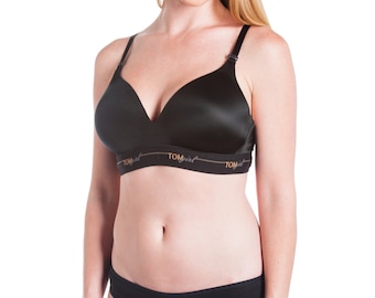 May include: A black wireless bra with adjustable straps and a smooth, seamless design. The bra has the word "Tomgirl" printed on the band.