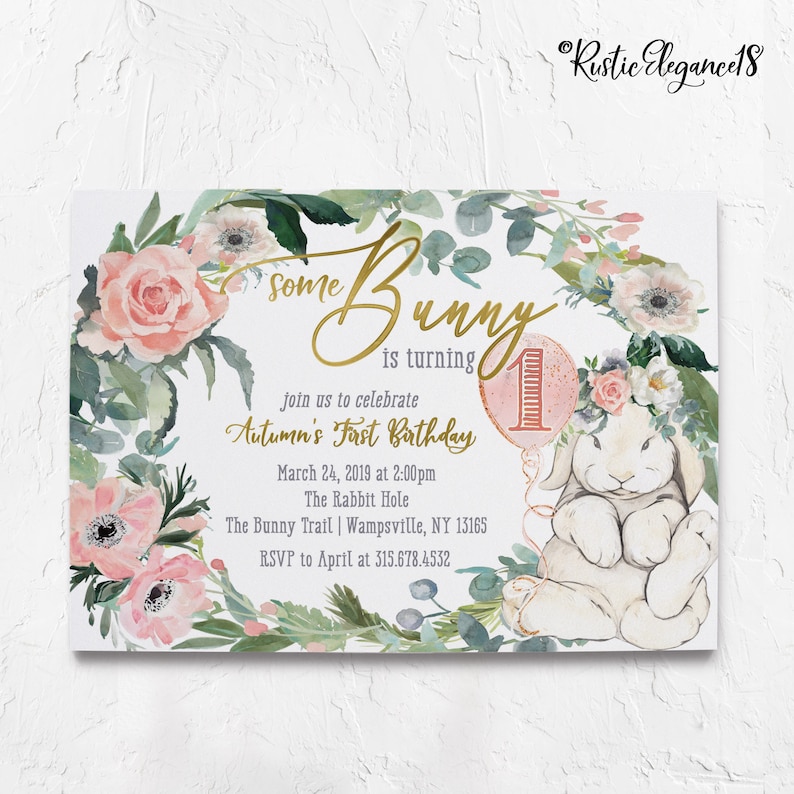 May include: A pink and green floral wreath with a white bunny holding a pink balloon with the number one on it. The text "Some Bunny is turning 1" is written in gold script. The text "Join us to celebrate Autumn's First Birthday" is written in black. The date, time, location, and RSVP information are also included.