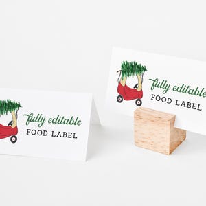 May include: A red toy wagon with a Christmas tree on top. The wagon has black wheels and is on a white background. The text "fully editable FOOD LABEL" is written in green on the card.