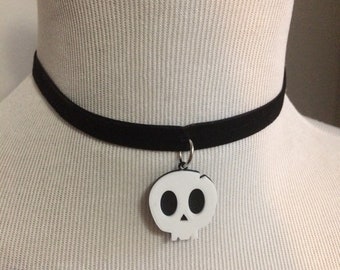 May include: A black velvet choker necklace with a white skull charm.