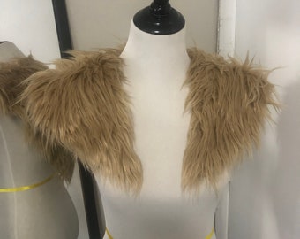 May include: A brown faux fur shrug with a V-neckline.