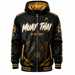 Op de afbeelding: Een zwarte hoodie met rits en gouden accenten, voorzien van de tekst "MUAY THAI" in het wit en Thaise tekens in het goud. De voorzijde toont een tijgergezicht, de mouwen hebben gouden patronen, een goud gevoerde capuchon en geribbelde boorden.