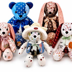 May include: A collection of five stuffed animals including a blue polka-dot bear, a brown floral rabbit, a pink floral rabbit, a white bear wearing a hat and vest, and a white rabbit with pumpkin embroidery and the text Pumpkin Patch.