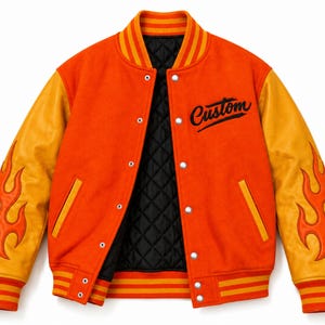 May include: An orange varsity jacket featuring yellow sleeves with orange flame appliques, a black quilted interior lining, and the word Custom embroidered in black script on the chest. The jacket has a snap button closure and striped ribbed trim.