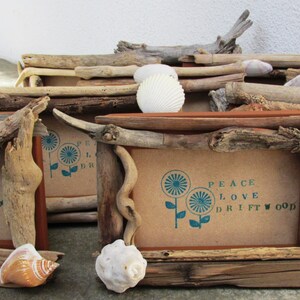 Puede incluir: Tres marcos de fotos rústicos hechos de madera a la deriva con una impresión de flores azul turquesa y el texto "Peace Love Driftwood".