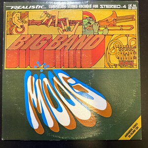 May include: Vintage vinyl record album cover for "Big Band" by Realistic. The cover features a colorful design with musical instruments and the album title in large, 3D orange letters. The background is green with abstract shapes.