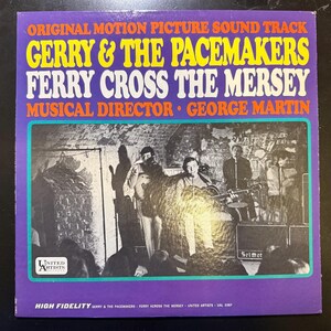 May include: A vintage vinyl record album cover for "Ferry Cross the Mersey" by Gerry & The Pacemakers. The cover is purple with yellow and white text. The album art features a black and white photo of the band performing.