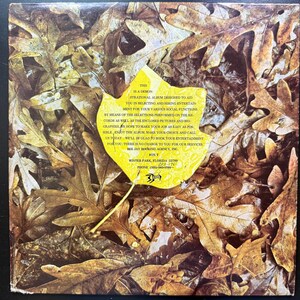 Op de afbeelding: Een geel blad met tekst over een muziekalbum dat is ontworpen om te helpen bij het selecteren van entertainment voor sociale functies. De tekst bevat de woorden "Tri-Mon", "Album", "Entertainment", "Sociale Functies", "Winter Park, Florida 32789" en "Box Jay Booking Agency, Inc.". Het blad is omgeven door een achtergrond van bruine en gele bladeren.