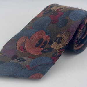May include: A brown, blue, red and tan patterned tie featuring a repeated design of Mickey Mouse.