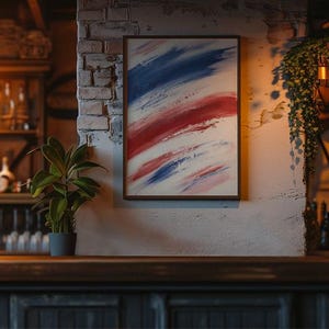 May include: A rectangular framed wall art piece featuring abstract brushstrokes in shades of red, white, and blue. The artwork is displayed on a textured white brick wall, positioned above a dark wooden bar counter in a dimly lit interior setting.
