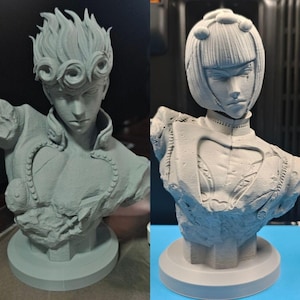 Puede incluir: Dos bustos de color gris claro impresos en 3D de personajes de anime. El busto izquierdo presenta un personaje con cabello rizado estilizado y un detalle en forma de corazón en el pecho. El derecho muestra un personaje con corte bob y chaqueta.