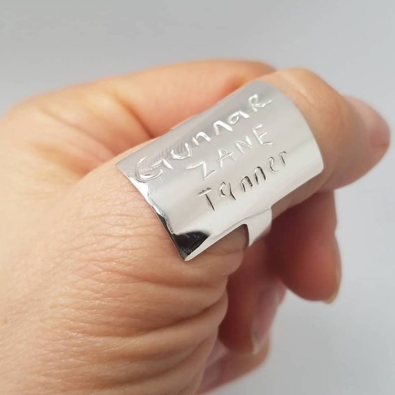 Puede incluir: Anillo de pulgar de plata con los nombres "Gunnar", "Zane" y "Tanner" grabados.