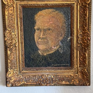 Puede incluir: Un retrato antiguo en un marco dorado y ornamentado. El retrato representa a una persona de piel clara y cabello claro. El marco tiene tallas detalladas y un acabado envejecido.