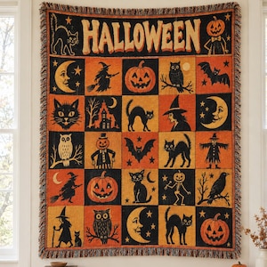 May include: A woven throw blanket featuring a grid of Halloween-themed illustrations in black and orange. The design includes pumpkins, cats, witches, owls, bats, and moons, with the word HALLOWEEN printed in large letters across the top border.