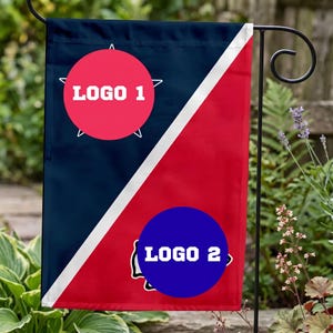 May include: A rectangular garden flag divided diagonally by a white stripe, featuring a dark blue section with a pink circular emblem labelled LOGO 1 and a red section with a blue circular emblem labelled LOGO 2, suspended on a black metal stand.