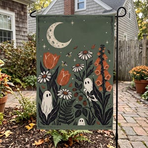 May include: A rectangular garden flag with a sage green background featuring a crescent moon, stars, and small ghosts among orange tulips, white daisies, foxgloves, ferns, and berries. Small bees fly between the flowers and foliage in this illustration.