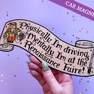 May include: A car magnet with a scroll design. The magnet features the text "Physically, I'm driving. Mentally, I'm at the Renaissance Faire!" and an illustration of a woman and a dagger. The magnet is tan with black text.