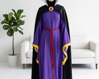 May include: A floor-length purple dress with long sleeves featuring yellow cuffs, paired with a black cape that has a high white collar. The outfit includes a gold-colored crown, a red rope belt, and a circular brooch with a red center stone.