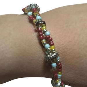 Pulsera triple de cuentas en tonos pastel, burdeos, dorado y plateado con dijes. Joyería bohemia de verano ajustable, hecha a mano, pulsera original para mujer.