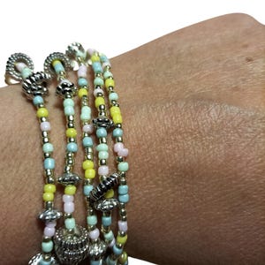 Pulsera de cinco hilos con cuentas y dijes en tonos pastel, dorados y plateados. Joyería bohemia veraniega ajustable hecha a mano, pulsera original para mujer.