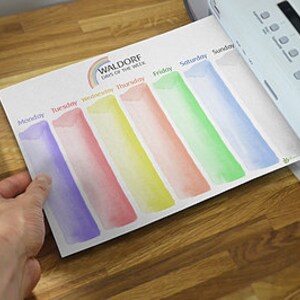 May include: A printable weekly planner with a rainbow design and the text "Waldorf Day of the Week". The planner has seven columns for each day of the week, Monday through Sunday.